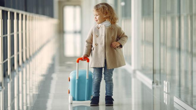 Niña con una maleta en un aeropuerto (Foto: Freepik)