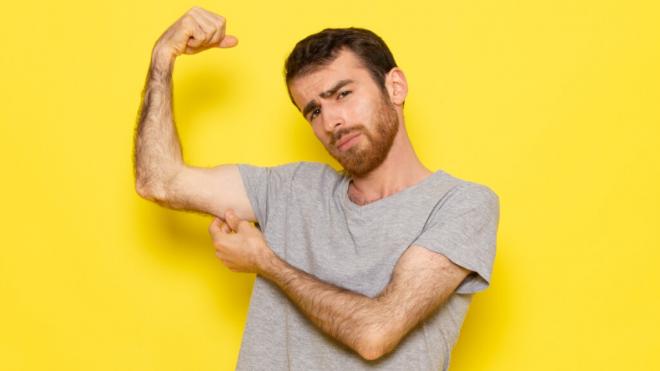 Hombre mostrando su falta masa muscular en el brazo (Foto: Freepik)