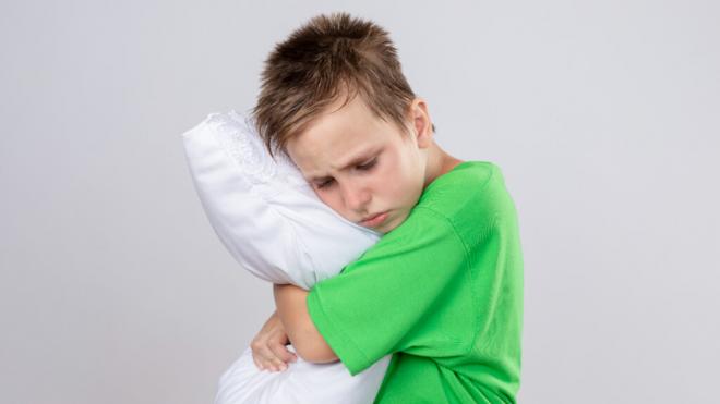 Niño dormido abrazado a una almohada (Foto: Freepik)