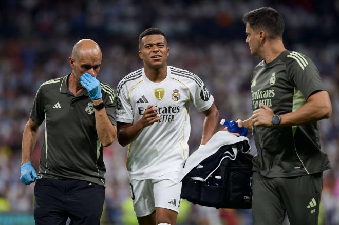 Kylian Mbappé es atendido por los servicios médicos del Real Madrid tras la entrada de Belardi (C