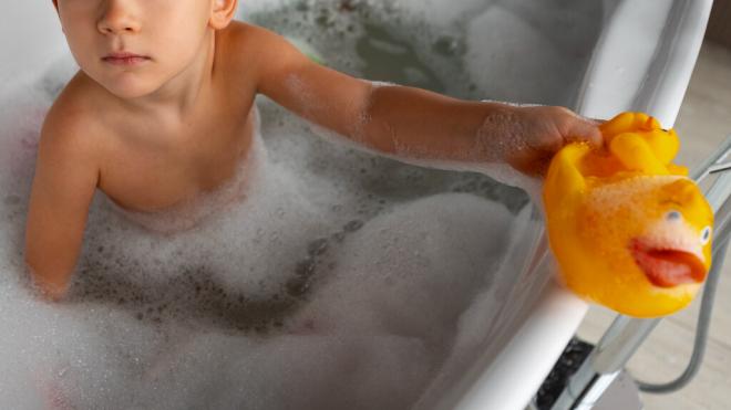 Niño jugando con un pato de goma en la bañera (Foto: Freepik)