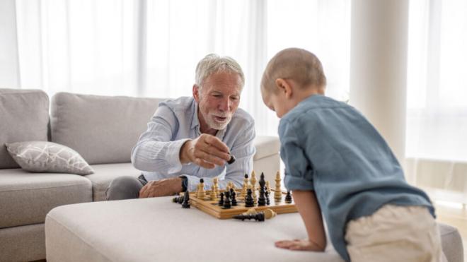 Nieto y abuelo jugando juntos al ajedrez (Foto: Freepik)