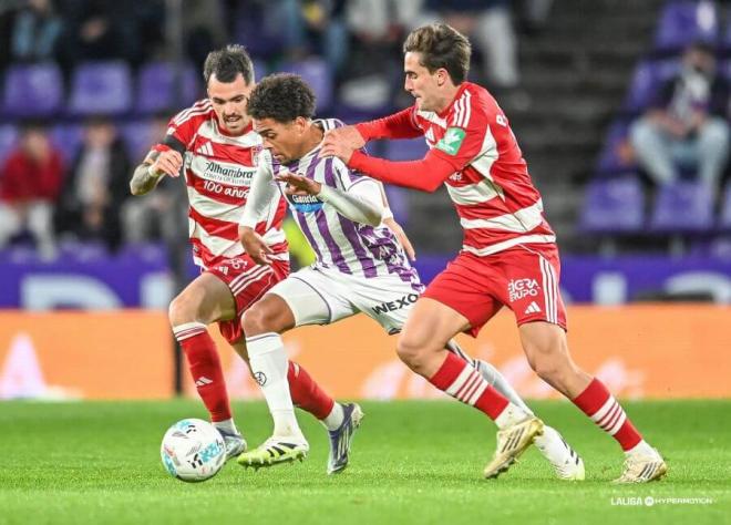 Julien Ponceau, encimado por varios futbolistas del Granada.