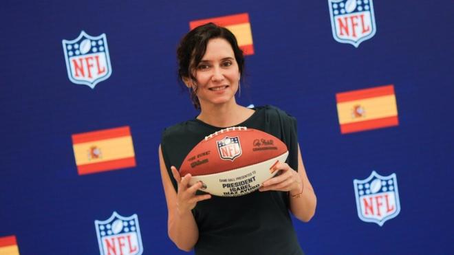 La presidenta de la comunidad de Madrid, Isabel Díaz Ayuso, con su balón personalizado de la NFL.