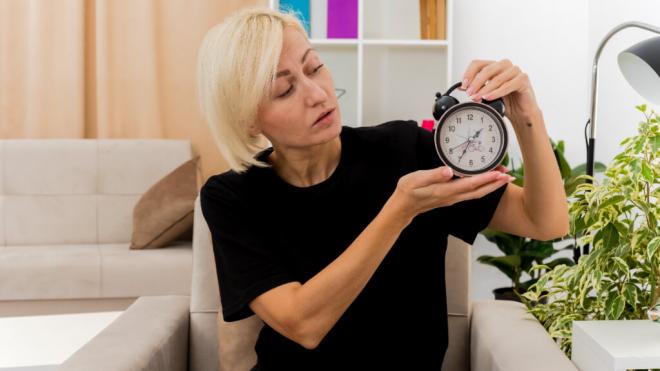 Mujer de edad media mirando un reloj (Foto: Freepik)