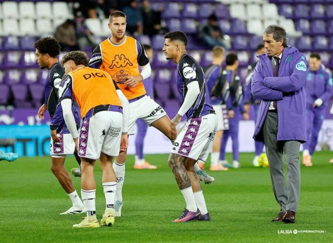 Jugadores del Real Valladolid calientan ante Las Palmas bajo la atenta mirada de Almada.