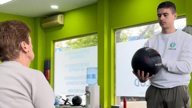 El entrenador personal Víctor Fernández trabajando con una persona mayor