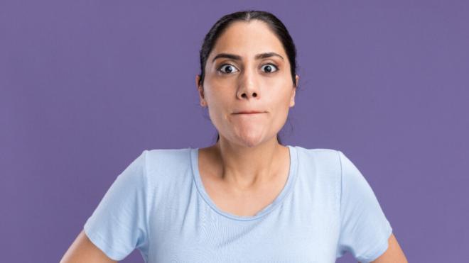 Mujer con la boca cerrada aguantando la respiración (Freepik)
