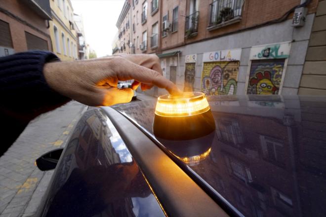 Una persona activa la baliza V16 en su coche (Foto: Europa Press).