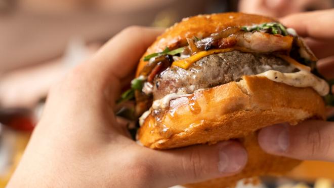 Persona comiéndose una hamburguesa de carne (Freepik)
