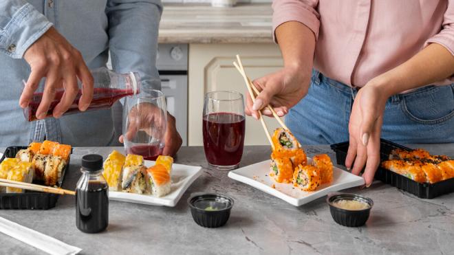 Pareja comiendo sushi en casa (Freepik)