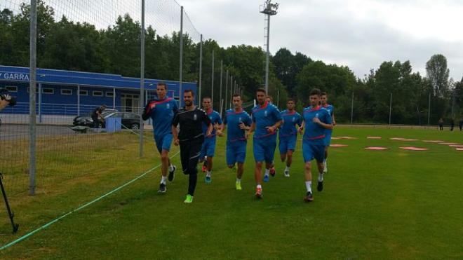 Los futbolistas corriendo sobre el césped de El Requexón.