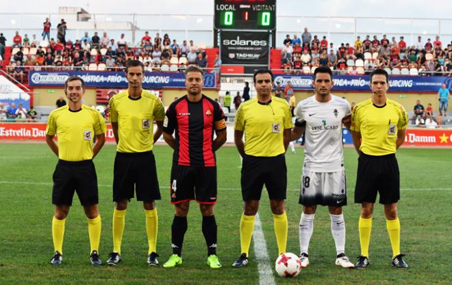 Los capitanes de ambos y equipos posan con los árbitros (Foto: Laia Solanellas).