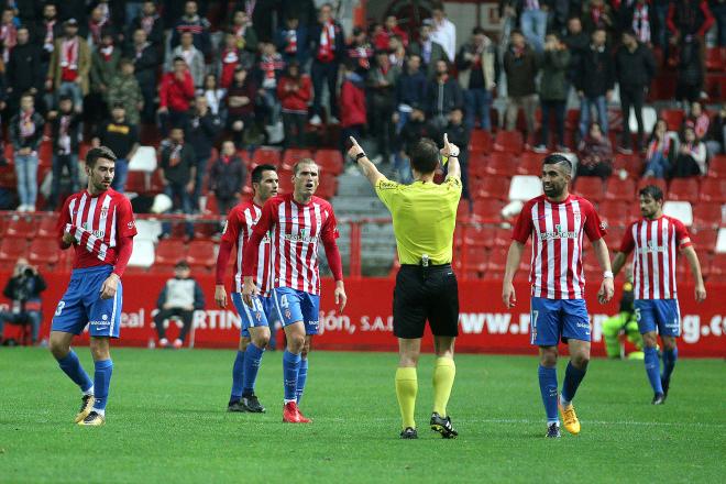 El árbitro se dirige a los jugadores del Sporting durante el partido (Foto: Luis Manso).