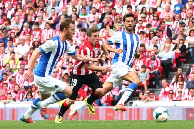 Muniain pugna con Zurutuza y Prieto en el derbi pasado.