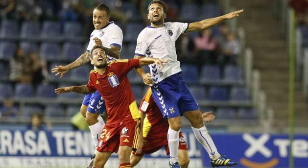 Manu Molina, entre dos jugadores del Tenerife (Foto: Web oficial del Recreativo)