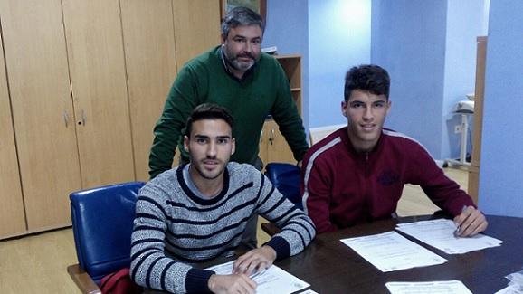 Los jóvenes futbolistas estampando su firma.