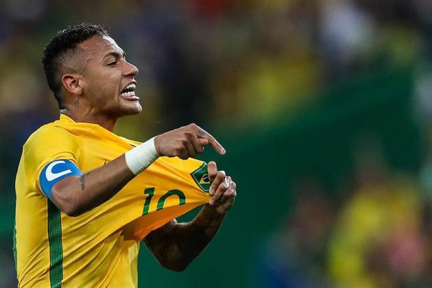 Neymar señala la bandera brasileña.