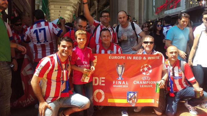 Un joven seguidor del Real Madrid junto a varios aficionados del Atlético.