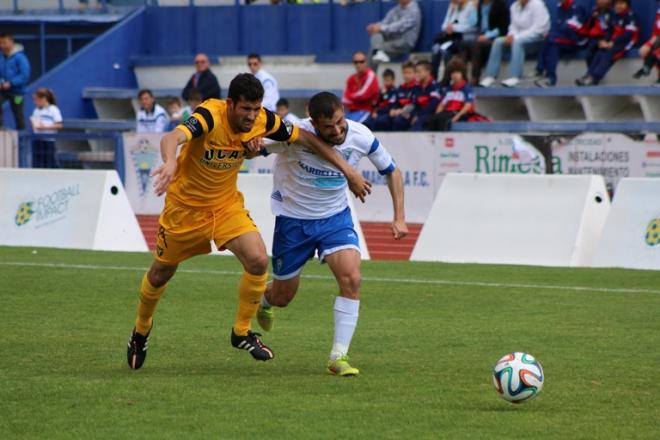 Jorge Giménez disputa un balón con un jugador visitante.