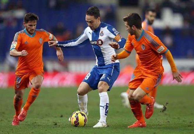 Sergio García conduce el balón entre jugadores del Valencia.