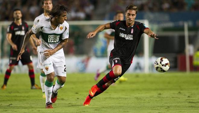 Jugadores del Elche y Granada pelean un balón en el encuentro de la ida.