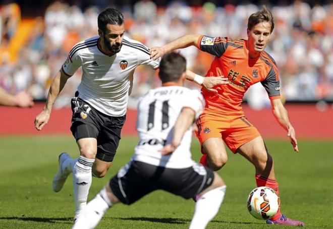 Canales conduce el balón ante dos jugadores del Valencia.