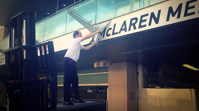 Operarios de McLaren cambiando carteles del equipo
