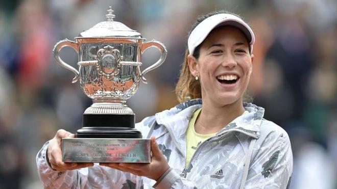Garbiñe sonríe tras conseguir el trofeo en Roland Garros.