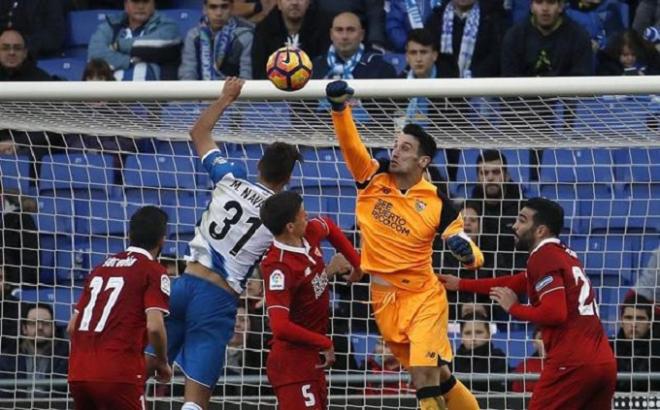 Sergio Rico despeja un balón con los puños.