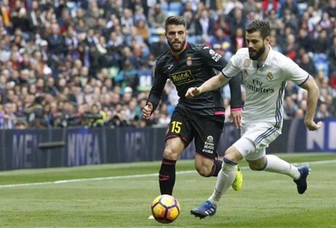 Carvajal protege la pelota, perseguido por David López.