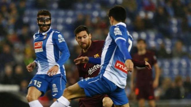 Messi controla el balón ante dos rivales.
