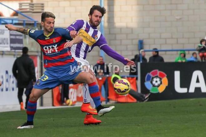 Chica trata de robar el balón a un jugador de la Llagostera.