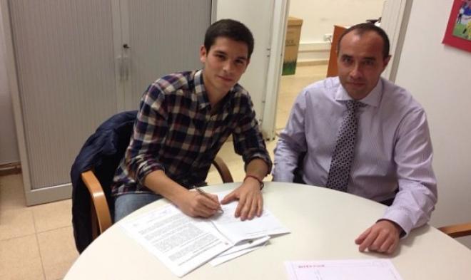 Alejandro firmando su nuevo contrato.