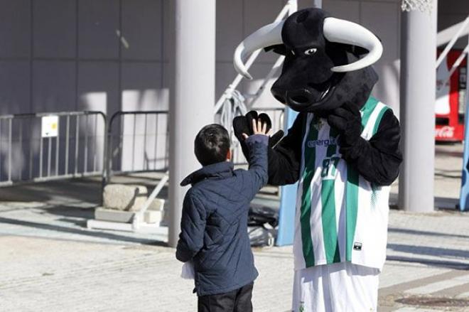 Un niño saluda a la mascota del Real Betis Energía Plus.