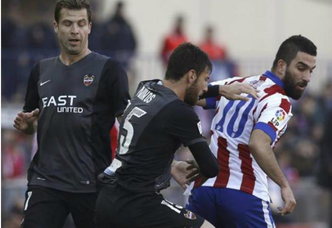 Nikos encima a Arda Turan en una acción del duelo entre el Atlético y el Levante UD