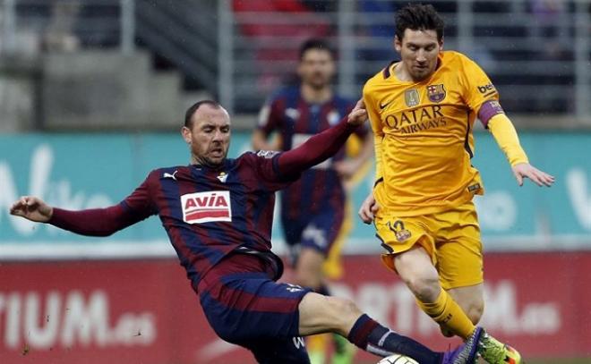 Ramis pugna por un balón con Leo Messi.