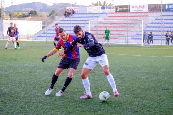 Txema Pan protege el balón ante la presión de un rival (Foto: Información Elda).