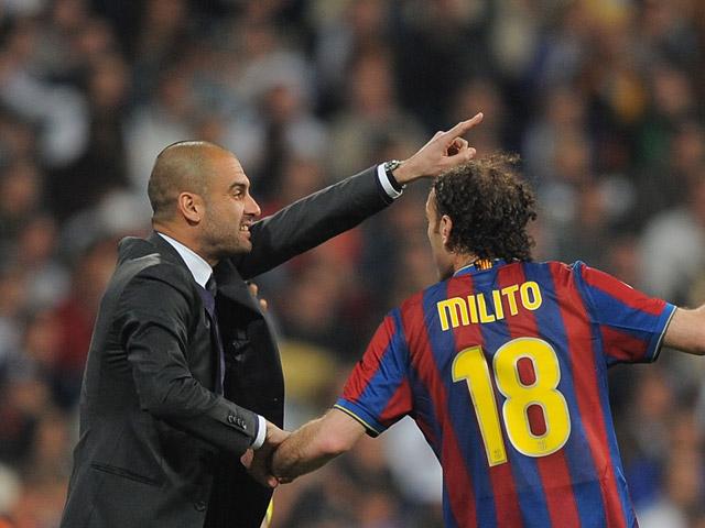 Pep Guardiola le da instrucciones a Gaby Milito en un partido con el Barcelona.