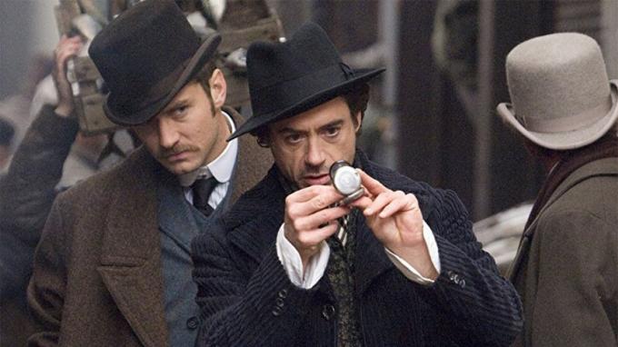 Sherlock Holmes mira su brújula bajo la atenta mirada del Doctor Watson (Foto: Warner Bros).