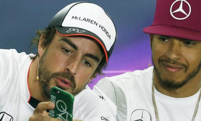 Fernando Alonso le enseña algo en el móvil a Lewis Hamilton en una rueda de prensa (Foto: EFE).