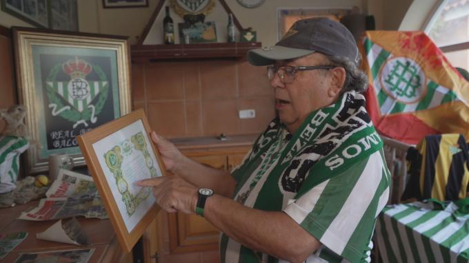 Juan Méndez enseña un diploma recibido por una peña Bética en el reportaje en ElDesmarque