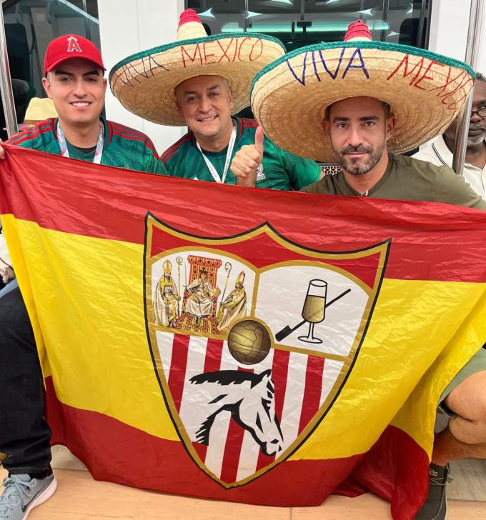 Nacho Almeda con la bandera del Sevilla junto a aficionados mexicanos