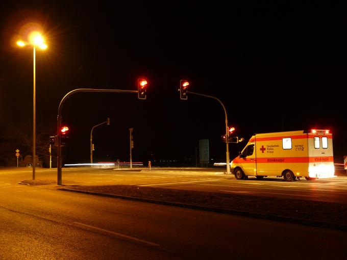 Una ambulancia, detenida en un cruce con el semáforo en rojo.